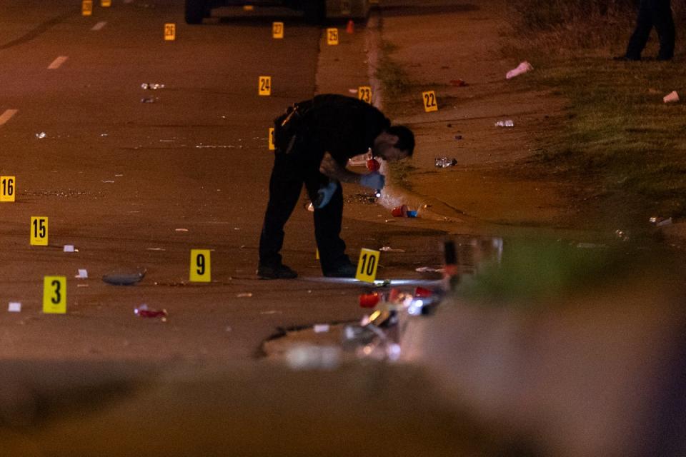 A police officer pictured at the scene of a shooting in Akron, Ohio on Sunday. Police say one person is dead and two dozen are injured (AP)