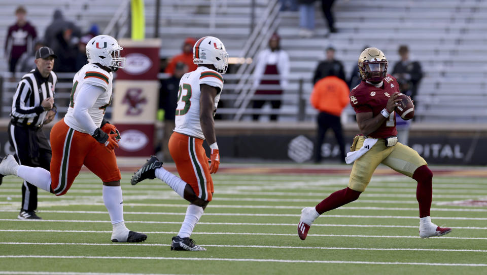 Boston College quarterback Thomas Castellanos (1) runs the ball ahead of the Miami defense during the second half of an NCAA college football game, Friday, Nov. 24, 2023, in Boston. (AP Photo/Mark Stockwell)