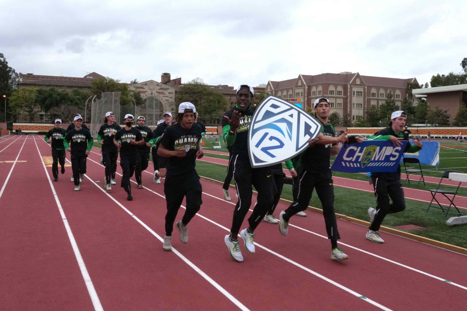 Members of the Oregon men's team take a victory lap after winning the Pac-12 title in 2021 in Los Angeles.
