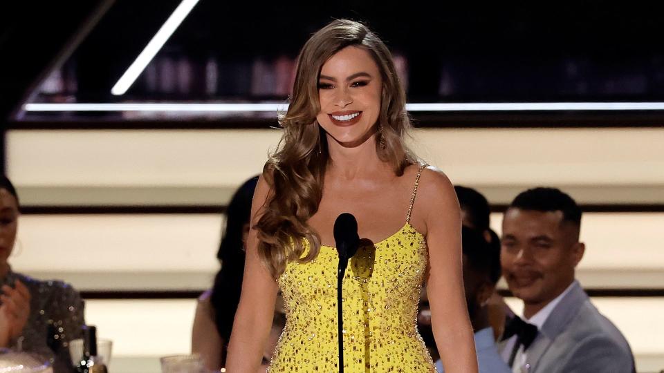 Sofia Vergara in yellow dress on stage