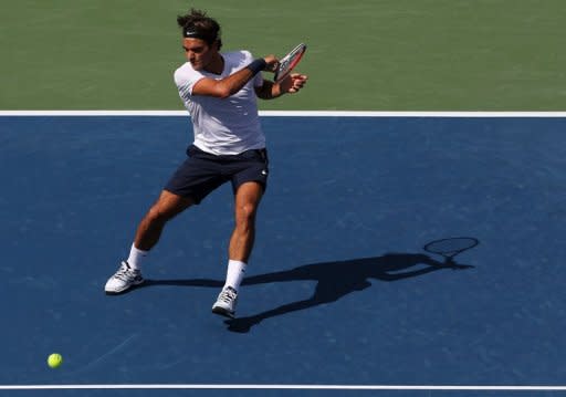 Roger Federer of Switzerland hits a forehand against Stanislas Wawrinka of Switzerland. Federer won 7-6 (7/4), 6-3