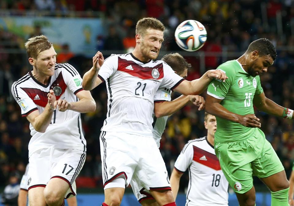 Germany's Per Mertesacker (L) and Shkodran Mustafi (2nd L) jump for the ball with Algeria's El Arabi Soudani (R) during their 2014 World Cup round of 16 game at the Beira Rio stadium in Porto Alegre June 30, 2014. REUTERS/Darren Staples