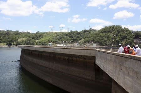 Officials of the Zimbabwe Electricity Supply Authourity (ZESA) inspect water levels on the Kariba dam in Kariba, Zimbabwe, February 19, 2016. REUTERS/Philimon Bulawayo