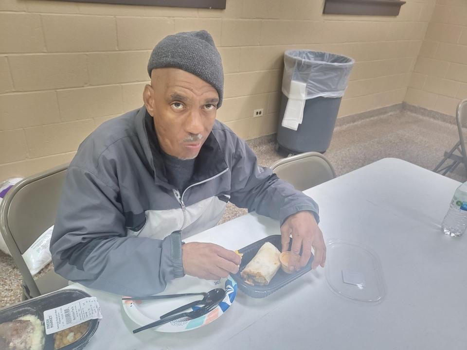 Deshawn Pettiford, of New Jersey, eats a meal provided by Lester and Jody Benoit at the Dumas Auditorium in Houma, January 19. The two feed the hungry with a trailer Lester set up to heat meals with a generator and microwaves.