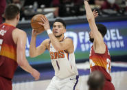 Phoenix Suns guard Devin Booker, center, goes up for a basket between Denver Nuggets center Nikola Jokic, left, and guard Austin Rivers in the first half of Game 4 of an NBA second-round playoff series Sunday, June 13, 2021, in Denver. (AP Photo/David Zalubowski)