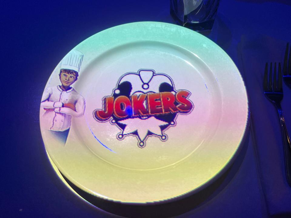 White plate at Le Petit Chef with the Jokers Comedy Club logo projected on it