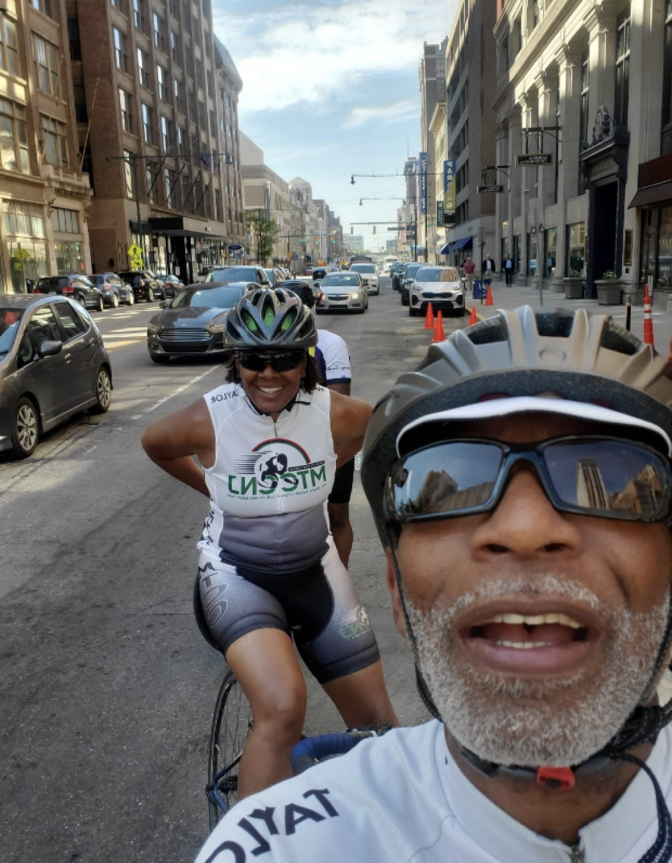 winston p lewis and a friend in the background taking a selfie on their bikes