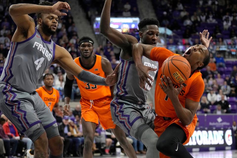 OSU guard Bryce Thompson (1) is fouled driving to the basket by TCU guard Damion Baugh (10) as center Eddie Lampkin Jr. (4) helps defend on the play in the first half Saturday in Fort Worth, Texas.