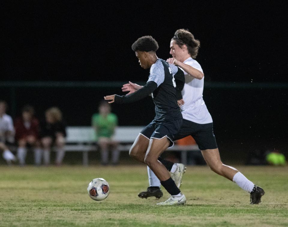 Justin Bolden (21) tries to hold off Evan Laye (15) whiles making a run on goal during the West Florida vs Tate boys soccer game at Ashton Brosnaham Park in Pensacola on Thursday, Jan. 5, 2023.