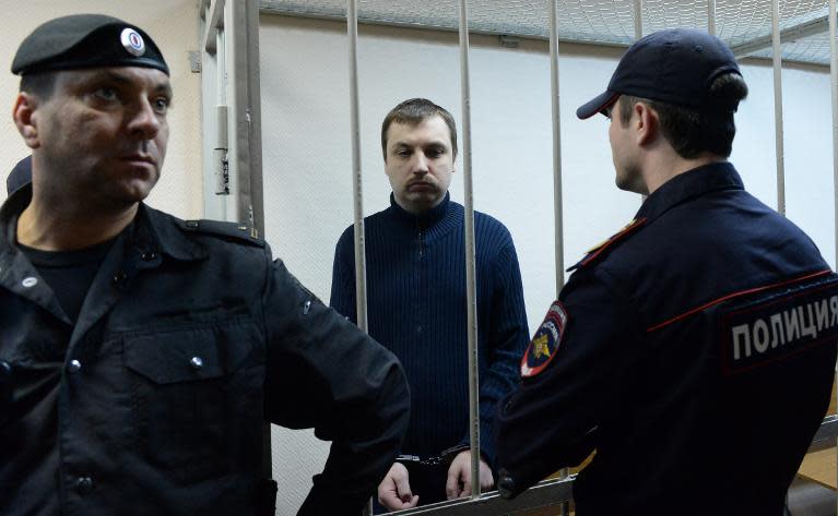 Mikhail Kosenko, an activist accused of violence at a rally on the eve of President Vladimir Putin's inauguration, stands in the defendant's cage in a court in Moscow, on October 8, 2013