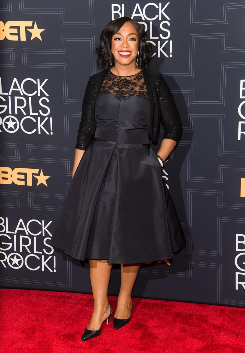 Shonda Rhimes in a black satin dress with lace detailing 