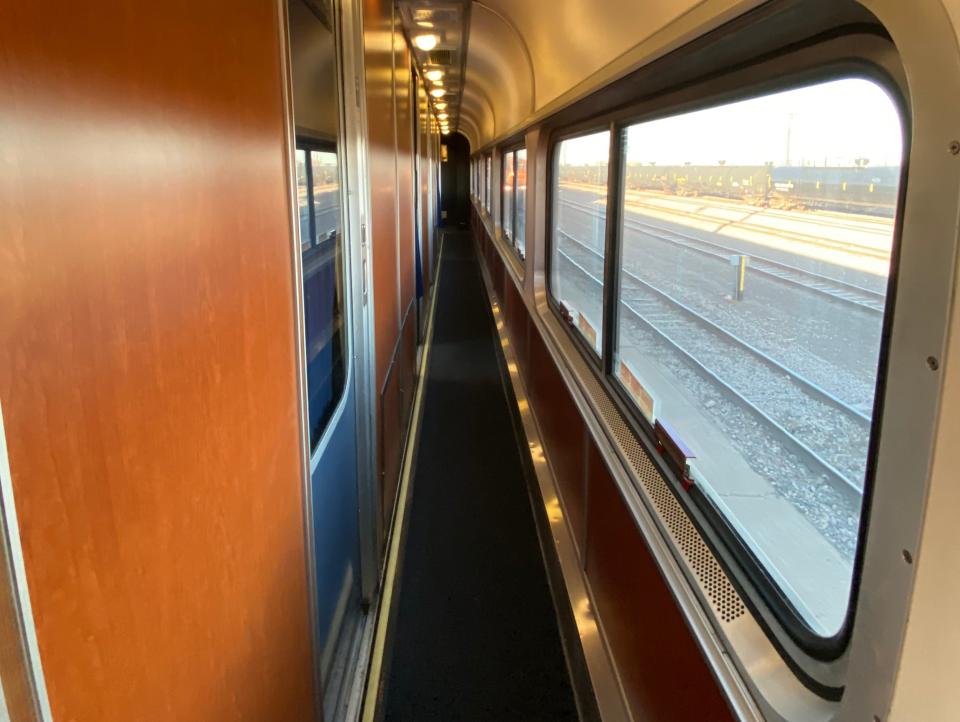 Inside view of narrow amtrak train hallway, with wooden walls and windows