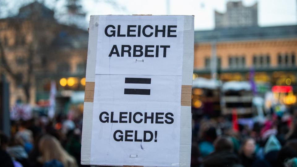 Eine Frau hält bei einer Demonstration in Hannover ein Plakat mit der Aufschrift «Gleiche Arbeit - gleiches Geld».