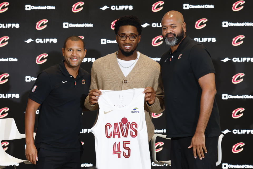 Cleveland Cavaliers guard Donovan Mitchell, center, holds up his jersey along with president of basketball operations Koby Altman, left, and head coach J.B. Bickerstaff during an NBA basketball news conference, Wednesday, Sept. 14, 2022, in Cleveland. (AP Photo/Ron Schwane)