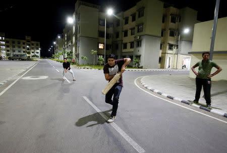 Residents play cricket under street lights at the Gujarat International Finance Tec-City (GIFT) at Gandhinagar, Gujarat, March 27, 2019. REUTERS/Amit Dave