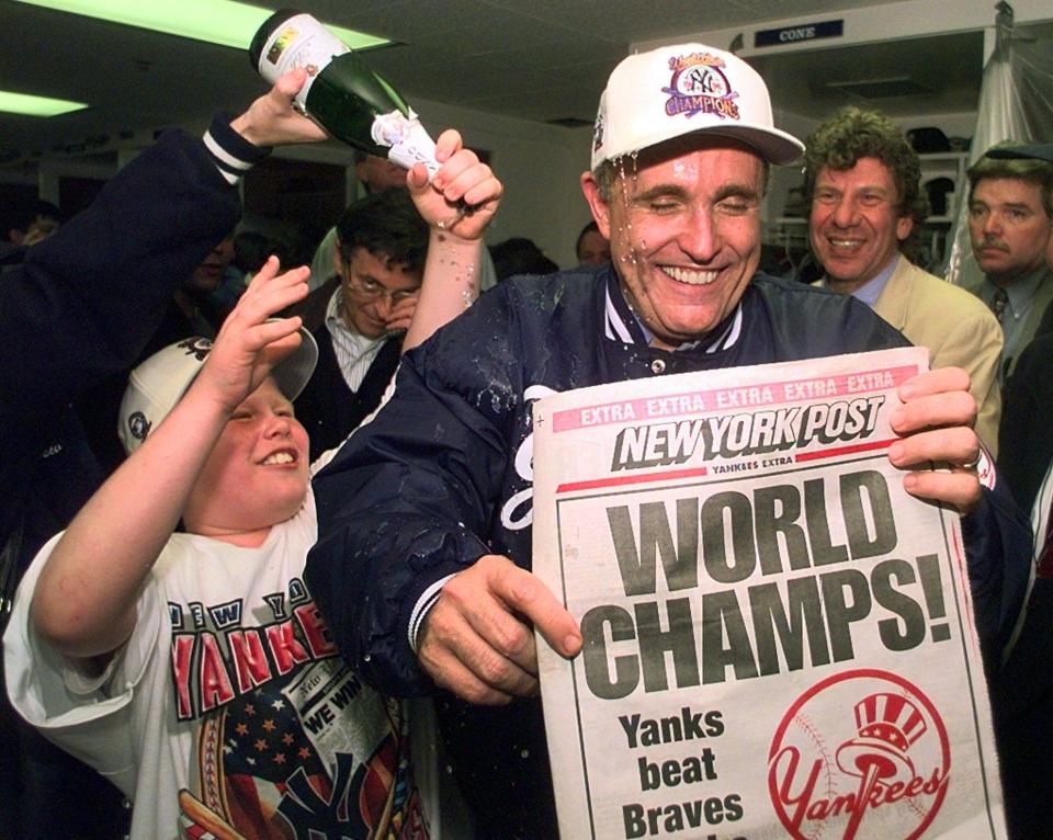 Andrew Giuliani, left, helps pour champagne on his father New York Mayor Rudolph Giuliani in the Yankees clubhouse after Game 6 of the World Series between the New York Yankees and the Atlanta Braves at Yankee Stadium in New York, Oct. 26, 1996. The Yankees won Game 6 3-2 to clinch the World Series.