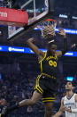 Golden State Warriors forward Jonathan Kuminga (00) dunks next to Memphis Grizzlies forward Santi Aldama, right, during the first half of an NBA basketball game Wednesday, March 20, 2024, in San Francisco. (AP Photo/Godofredo A. Vásquez)