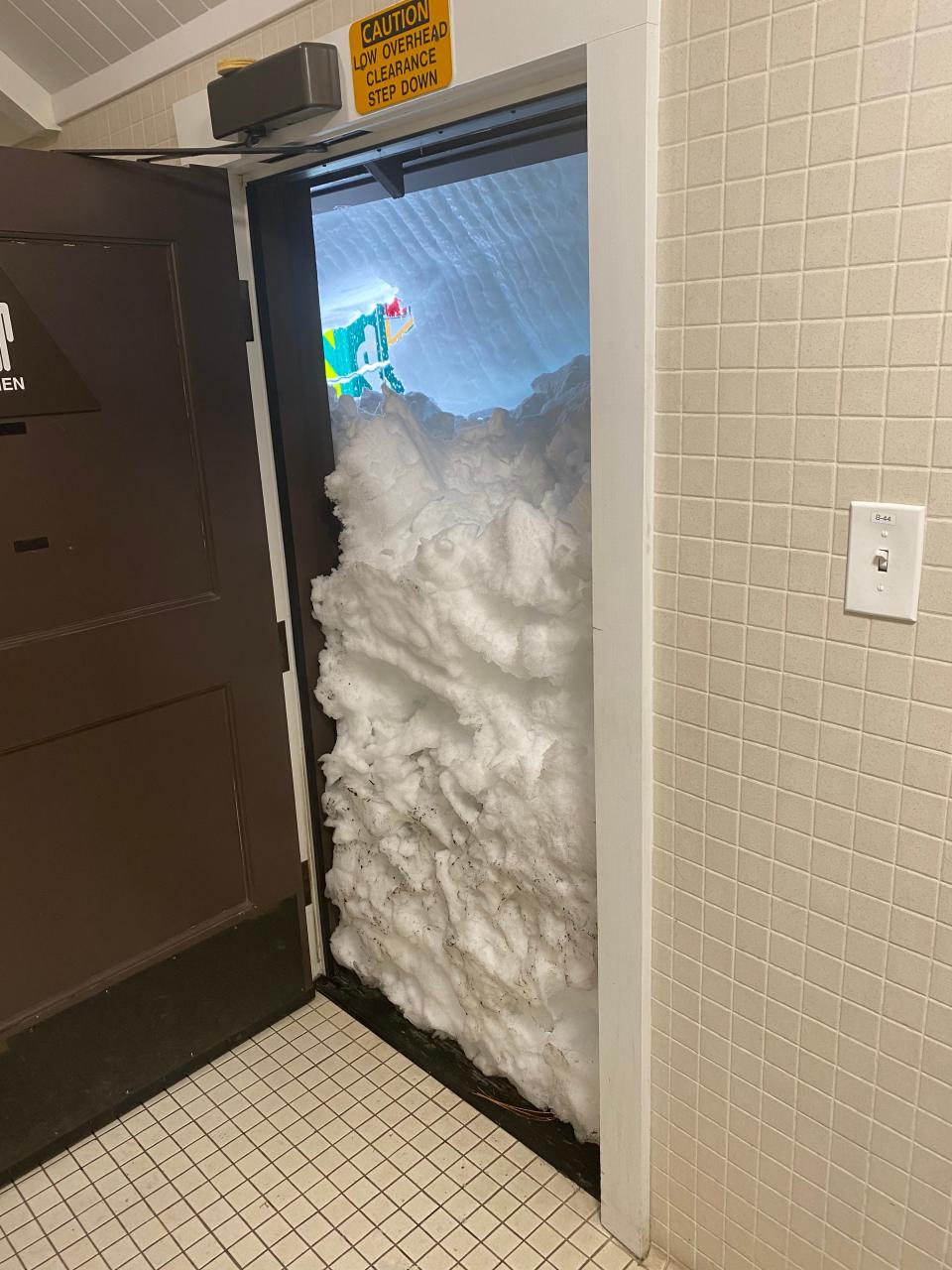 Snow nearly covers the entrance to a bathroom at Yosemite National Park.