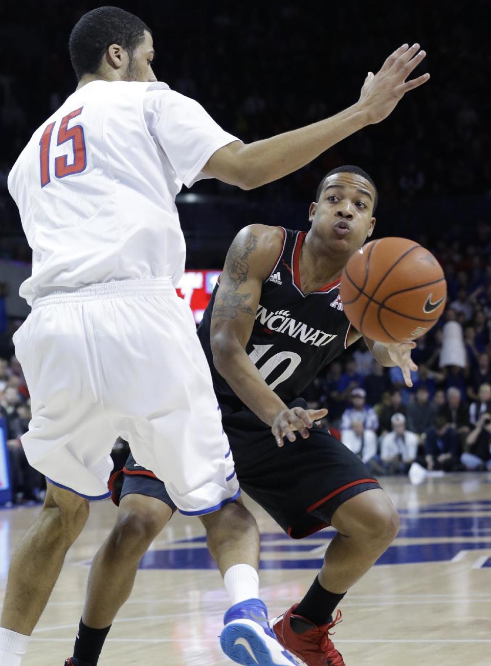 Cincinnati guard Troy Caupain (10) passes around SMU center Cannen Cunningham (15) during the first half of an NCAA college basketball game Saturday, Feb. 8, 2014, in Dallas. (AP Photo/LM Otero) vcb