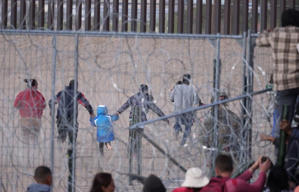 A video still shows Migrants breaching barriers set by the Texas National Guard on the Rio Grande in El Paso, Texas on April 12, 2024.