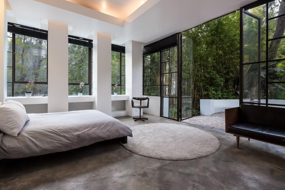 A look inside a bedroom that opens up to a balcony overlooking the swimming pool.