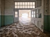 <p>Sand fills the corridor of this abandoned hospital in a ghost town in Africa.</p>