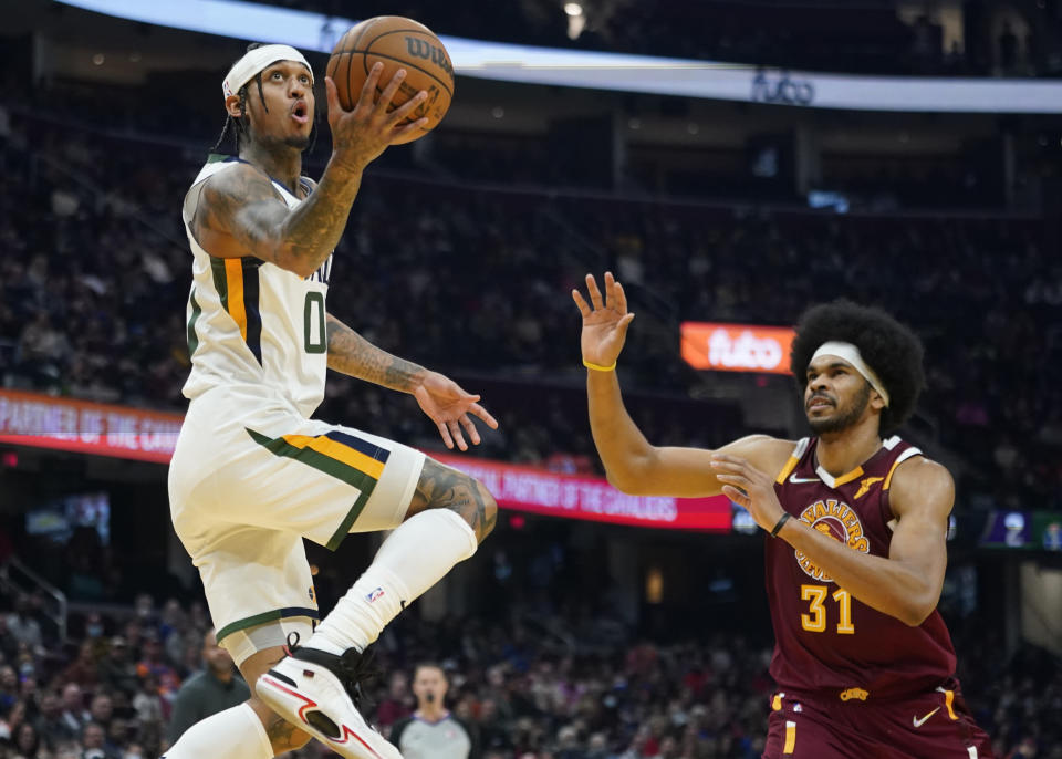 Utah Jazz's Jordan Clarkson (00) drives to the basket against Cleveland Cavaliers' Jarrett Allen (31) in the first half of an NBA basketball game, Sunday, Dec. 5, 2021, in Cleveland. (AP Photo/Tony Dejak)