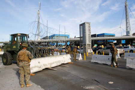 U.S. Marines stand next to a barricade with concertina wire, at the border between Mexico and the U.S., in preparation for the arrival of migrants, in Tijuana, Mexico November 13, 2018. REUTERS/Jorge Duenes