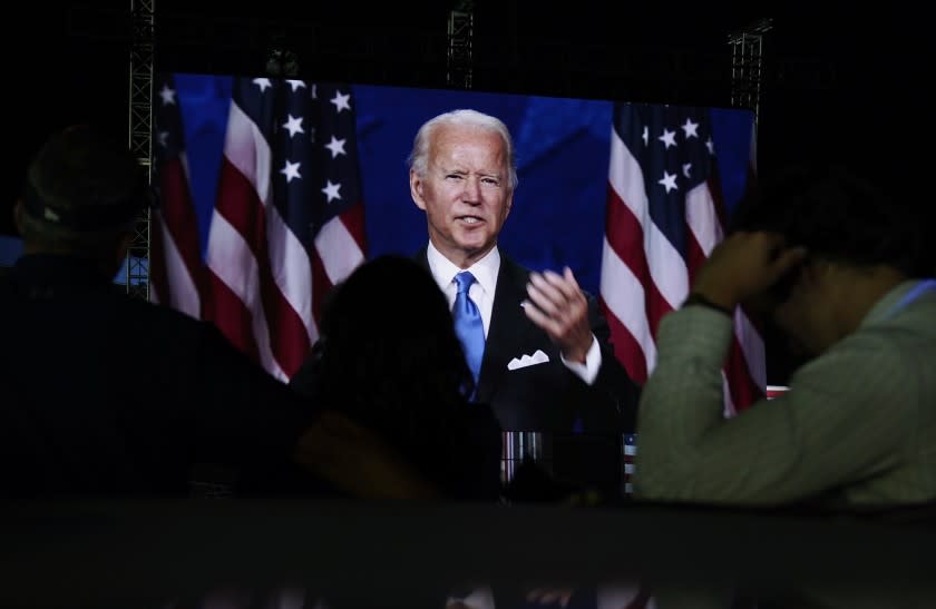 Supporters watch the program outside the venue where Democratic presidential candidate former Vice President Joe Biden is speaking, during the final day of the Democratic National Convention, Thursday, Aug. 20, 2020, at the Chase Center in Wilmington, Del. (AP Photo/Carolyn Kaster)