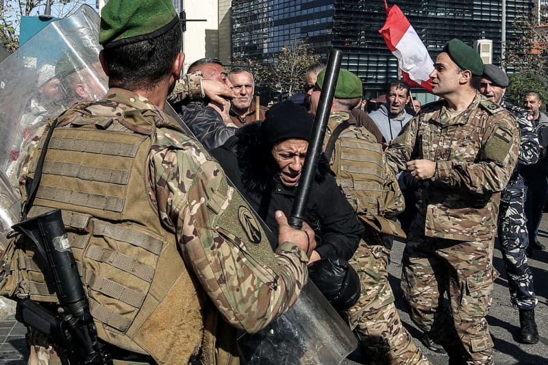 Lebanese soldiers securing a local bank scuffle with protesters during a protest to demand the imposition of a timetable for returning the savings of depositors. The protests of depositors against banks has been expressed regularly since the restrictions imposed by the Lebanese banks in 2019, at the start of an unprecedented economic crisis in which Lebanon is still entangled. Marwan Naamani/dpa