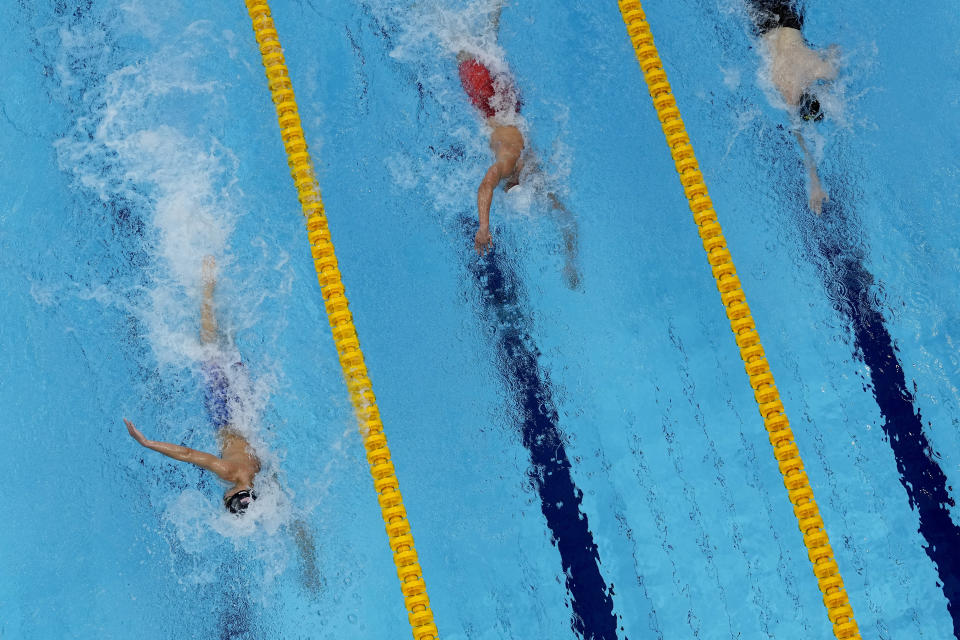 Robert Finke, left, of the United States, swims win the gold medal ahead of silver medalist Mykhailo Romanchuk, of Ukraine, and bronze medalist Florian Wellbrock, right, of Germany, in the men's 1500-meter freestyle final at the 2020 Summer Olympics, Sunday, Aug. 1, 2021, in Tokyo, Japan. (AP Photo/Jeff Roberson)