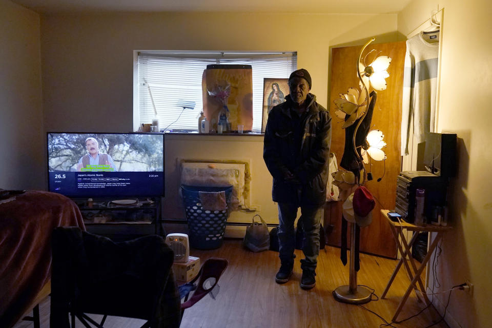 Rudolph Williams stands for a portrait in his apartment bedroom Monday, Jan. 8, 2024, in Harvey, Ill. Williams was home in the Chicago south suburb when he realized that the doors and windows to his courtyard-style apartment had been boarded up with plywood, locking him inside.(AP Photo/Charles Rex Arbogast)