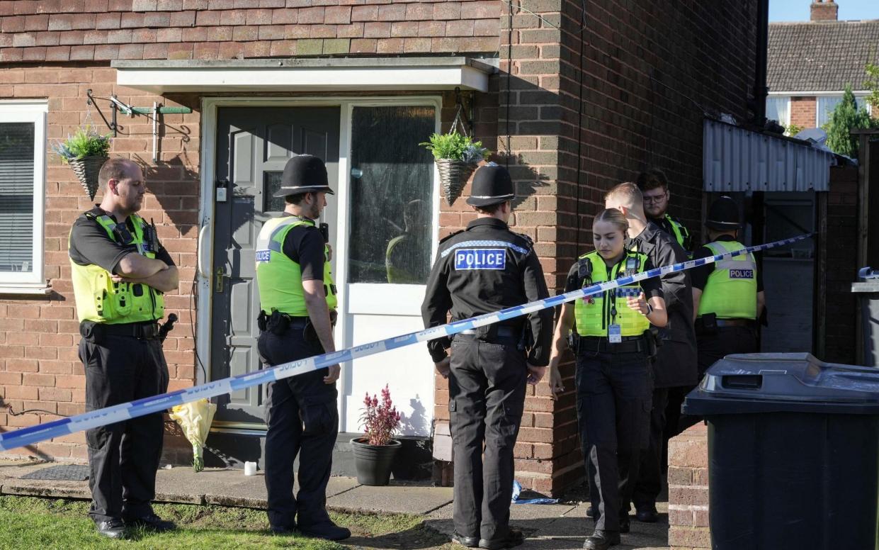 Police officers stand outside a house in Oldbury where a boy was found with stab wounds