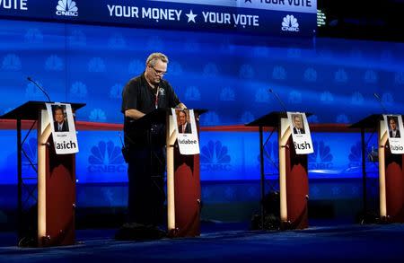 A technician works on the podium for Mike Huckabee for tomorrow's Republican presidential candidate debate on stage in Boulder, Colorado, October 27, 2015. REUTERS/Rick Wilking