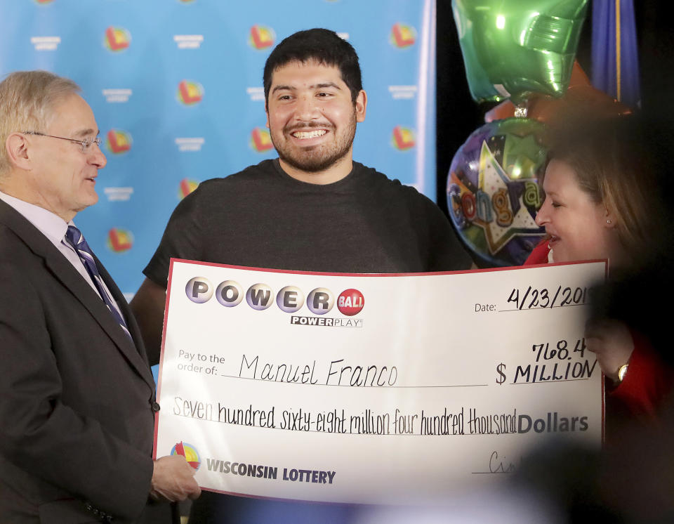 Manuel Franco of West Allis, Wis., winner of second-highest Powerball lottery in history, attends a news conference at the Wisconsin Department of Revenue in Madison, Wis., on Tuesday, April 23, 2019. At right is Peter Barca, state secretary of revenue, and at right is Cindy Polzin, state lottery director. Franco claimed the cash option payout of the prize, totaling approximately $477 million before taxes. The overall jackpot of the prize, drawn March 22, was $768,400. (John Hart/Wisconsin State Journal via AP)