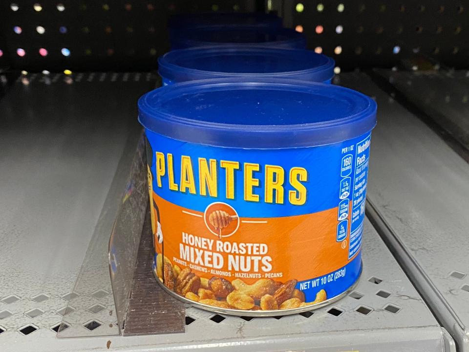 a container of mixed nuts on an empty shelf with a sign that reads $4.62