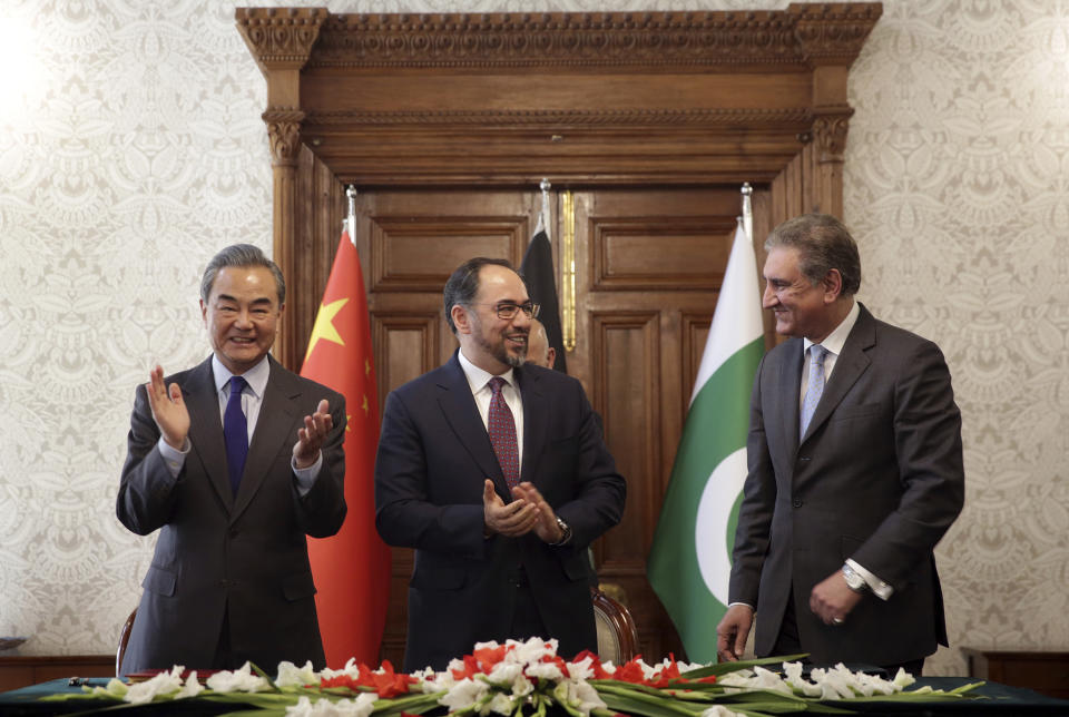 Afghanistan's Minister of Foreign Affairs Salahuddin Rabbani, center, Pakistan's Foreign Minister Shah Mehmood Qureshi, right, and Chinese Foreign Minister Wang Yi clap after signing the agreement during a meeting at the presidential palace in Kabul, Afghanistan, Saturday, Dec. 15, 2018. Afghanistan, Pakistan, and China are meeting in the Afghan capital to discuss trade, development and ending the region's relentless conflicts. (AP Photo/Massoud Hossaini