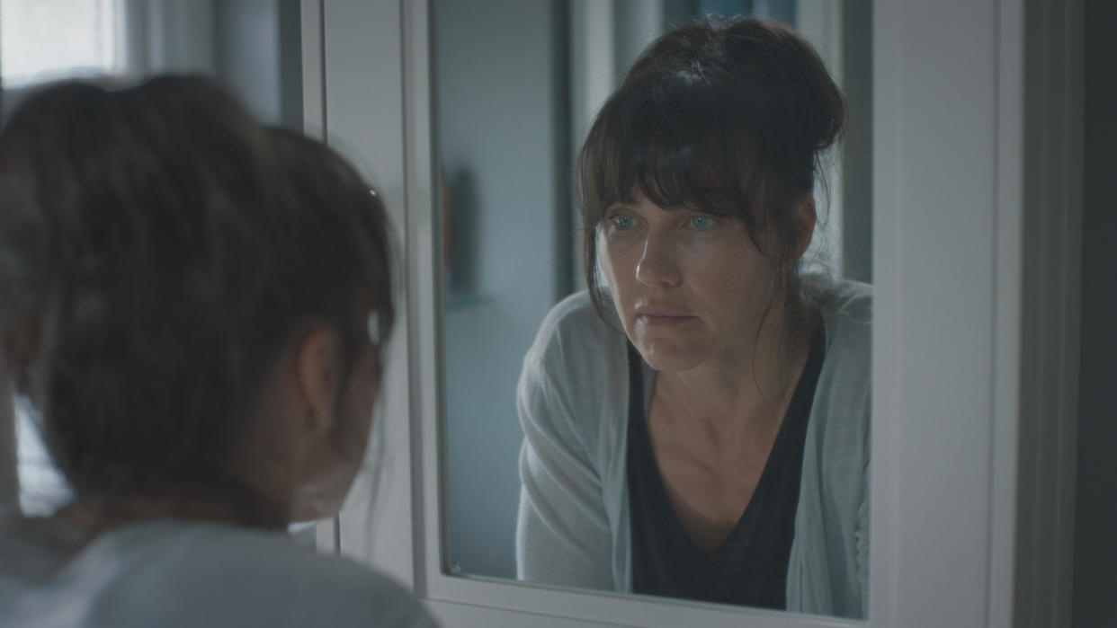  Faith (Kirsty Mitchell) looks at her reflection in Casualty 