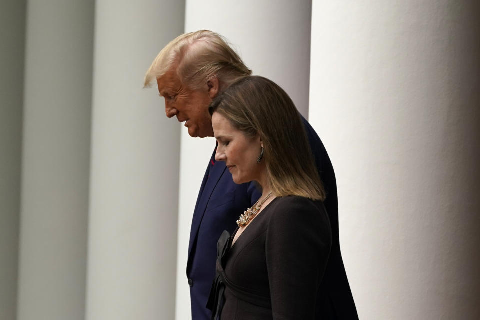 President Donald Trump walks with Judge Amy Coney Barrett to a news conference to announce Barrett as his nominee to the Supreme Court, in the Rose Garden at the White House, Saturday, Sept. 26, 2020, in Washington. (AP Photo/Alex Brandon)