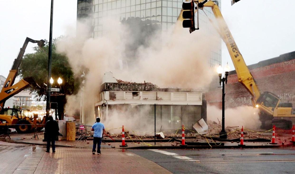 Mark and Mike Mangham of Twin Blends get photos of the demolition of the historic building on 421 Market St. in downtown Shreveport on May 5, 2024. It recently was home to Dripp Donuts and for years before housed Dee's Photo Supply.