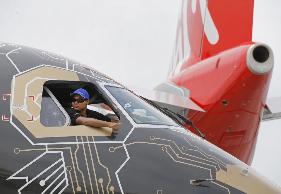 A pilot of an Embraer Profit Hunter E195-E2 makes the thumbs up sign as he on the tarmac at Paris Air Show, in Le Bourget, east of Paris, France, Tuesday, June 18, 2019. The world's aviation elite are gathering at the Paris Air Show with safety concerns on many minds after two crashes of the popular Boeing 737 Max. (AP Photo/Michel Euler)