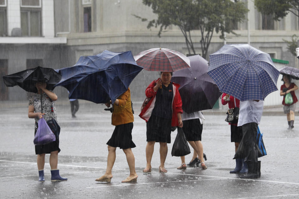 Pedestrians shield themselves from wind and rain brought by Typhoon Lingling Saturday, Sept. 7, 2019, in Pyongyang, North Korea. The typhoon passed along South Korea’s coast has toppled trees, grounded planes and caused at least two deaths before making landfall in North Korea. (AP Photo/Jon Chol Jin)