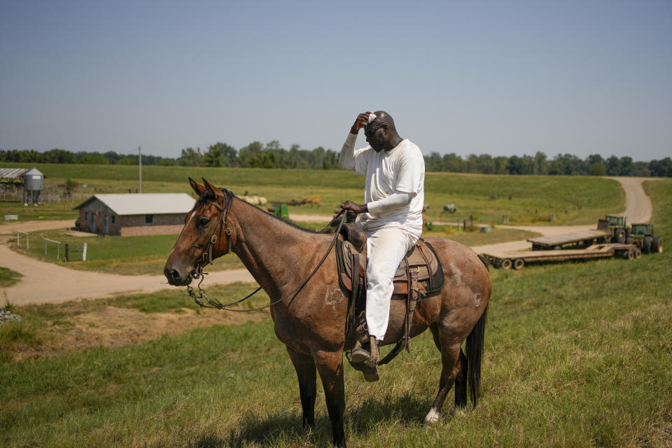 Prisoner Michael Jefferson wipes away sweat while herding cattle at the Cummins Unit of Arkansas' Department of Corrections, Friday, Aug. 18, 2023, in Gould, Ark. Big-ticket items like row crops and livestock are sold on the open market, with profits fed back into agriculture programs. (AP Photo/John Locher)