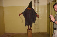 FILE - This is a 2003 file image obtained by The Associated Press which shows an unidentified detainee standing on a box with a bag on his head and wires attached to him in late 2003 at the Abu Ghraib prison in Baghdad, Iraq. An Iraqi Justice Ministry official said Wednesday, April 16, 2014 that this week's closure of the infamous Abu Ghraib prison west of Baghdad is temporary and that it will be reopened once the security situation in the surrounding area is stable. The closure is the latest chapter in the history of the prison, which during Saddam Hussein's rule was one of the main facilities for jailing and executing his opponents. After the U.S.-led invasion that toppled Saddam, Abu Ghraib became notorious once again, for a 2004 scandal over abuses of detainees by American guards. (AP Photo, File)