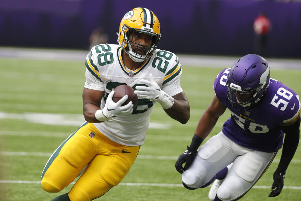 Green Bay Packers running back AJ Dillon (28) runs from Minnesota Vikings linebacker Jordan Hicks (58) during the first half of an NFL football game, Sunday, Sept. 11, 2022, in Minneapolis. (AP Photo/Bruce Kluckhohn)