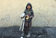 An internally displaced boy poses for a photograph outside his temporary home in the city of Kabul, Afghanistan, Wednesday, Dec. 30, 2020. Save the Children has warned that more than 300,000 Afghan children face freezing winter conditions that could lead to illness, in the worst cases death, without proper winter clothing and heating. (AP Photo/Rahmat Gul)