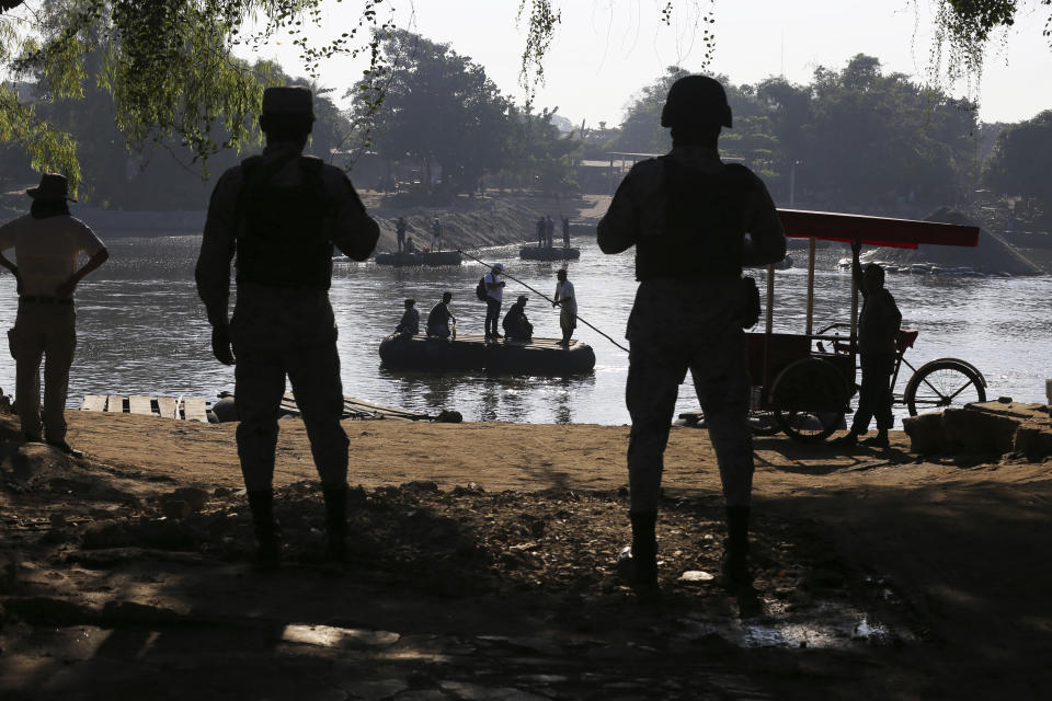 Mexican National Guards stand watch over the Suchiate River where locals transport cargo and ferry people between Mexico and Guatemala, near Ciudad Hidalgo, Mexico, Friday, Jan. 24, 2020, a location popular for Central American migrants to cross from Guatemala to Mexico. One National guard said it’s easy to distinguish local Guatemalans who cross for ordinary workday reasons for their manner of speaking, and they’re welcome “because they’re neighbors.” (AP Photo/Marco Ugarte)