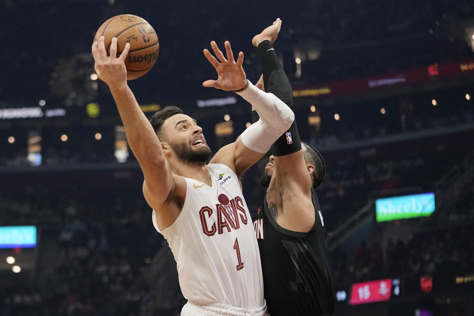 Cleveland Cavaliers guard Max Strus (1) shoots next to Houston Rockets forward Jae'Sean Tate in the first half of an NBA basketball game, Monday, Dec. 18, 2023, in Cleveland. (AP Photo/Sue Ogrocki)