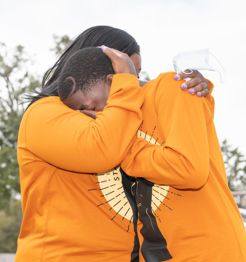 Katie Rogers comforts her son, Scottie Motton, a 13-year-old sixth grader, in front of Bellview Middle School in Pensacola on Wednesday. Rogers alleges Motton, who has been suspended from the school, was slapped by a teacher.