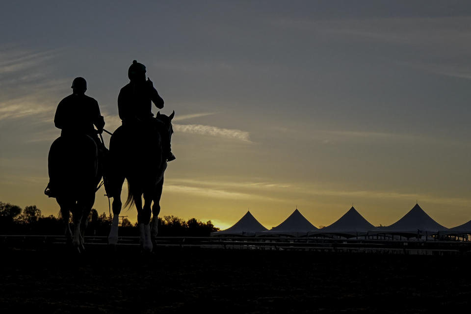 Horse trainer D. Wayne Lukas, left, rides atop Riff as he helps exercise rider Oscar Quevedo and Preakness entrant Secret Oath onto the track for a morning workout ahead of the Preakness Horse Race at Pimlico Race Course, Wednesday, May 18, 2022, in Baltimore. Lukas believes Secret Oath could be one of the best fillies he has ever had. That belief and her winning the Kentucky Oaks in impressive fashion the day before the Derby inspired him to enter Secret Oath in the Preakness Stakes, where she could give the 86-year-old Hall of Fame trainer a record-tying seventh victory in the second jewel of the Triple Crown. (AP Photo/Julio Cortez)